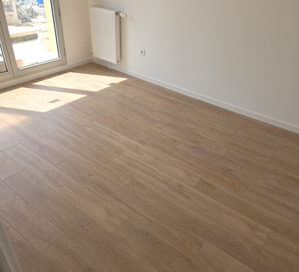 Après&nbsp;: la même chambre avec le revêtement de sol posé et les plinthes