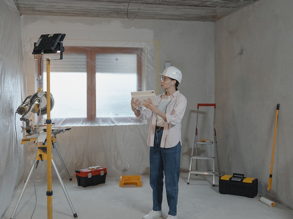 Cheffe de chantier avec une tablette dans un logement en travaux