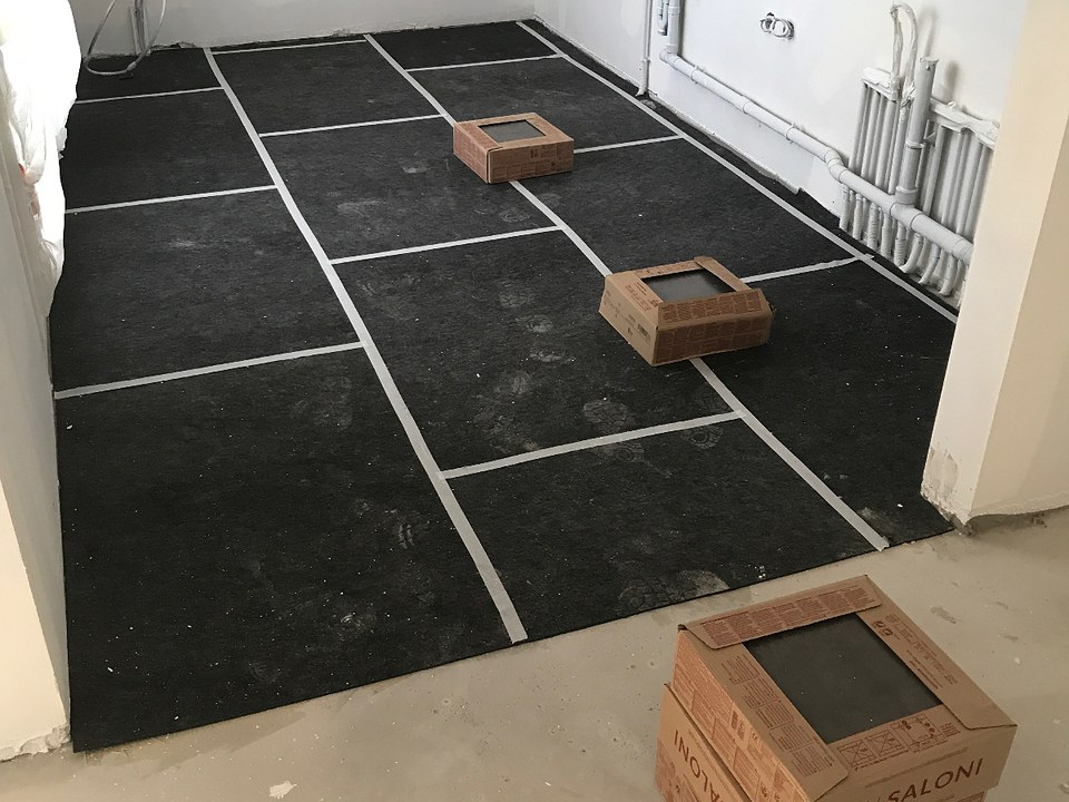 Photo prise sur un chantier Arcancia : sol protégé et carrelage en attente de pose