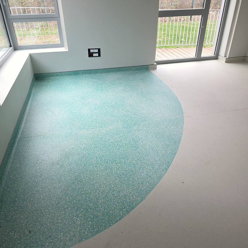 Sol PVC turquoise posé avec une découpe courbe, chantier Arcancia